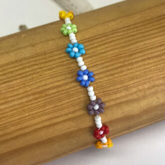 Rainbow-Daisy-Chain-White-Bracelet-on-Wooden-Pole